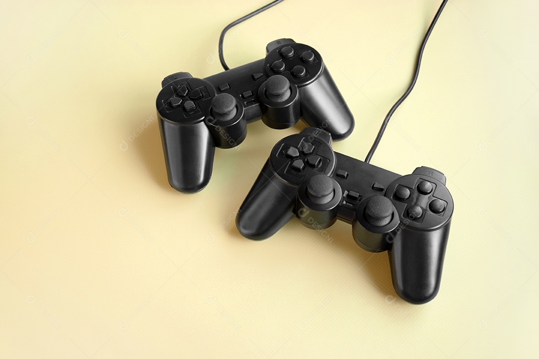 Controles de videogame preto sobre fundo amarelo