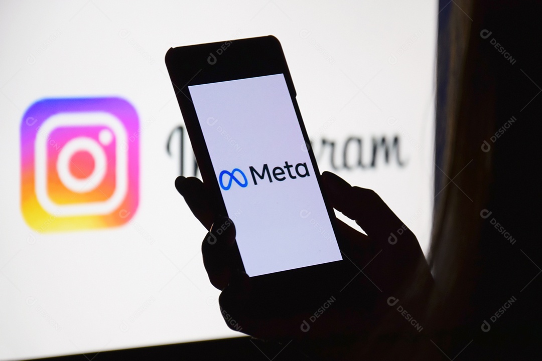 Mulher com celular nas mãos com aplicativo Meta e monitor ao fundo com Instagram