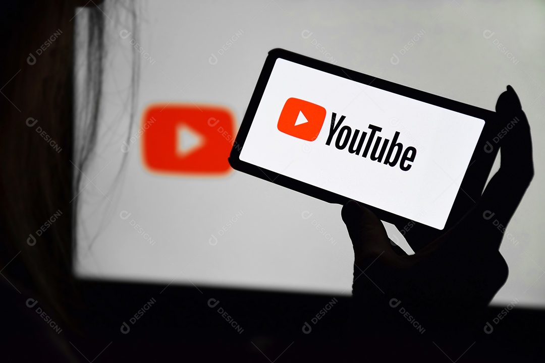 Tela Youtube nas mãos de uma jovem contra fundo de monitor