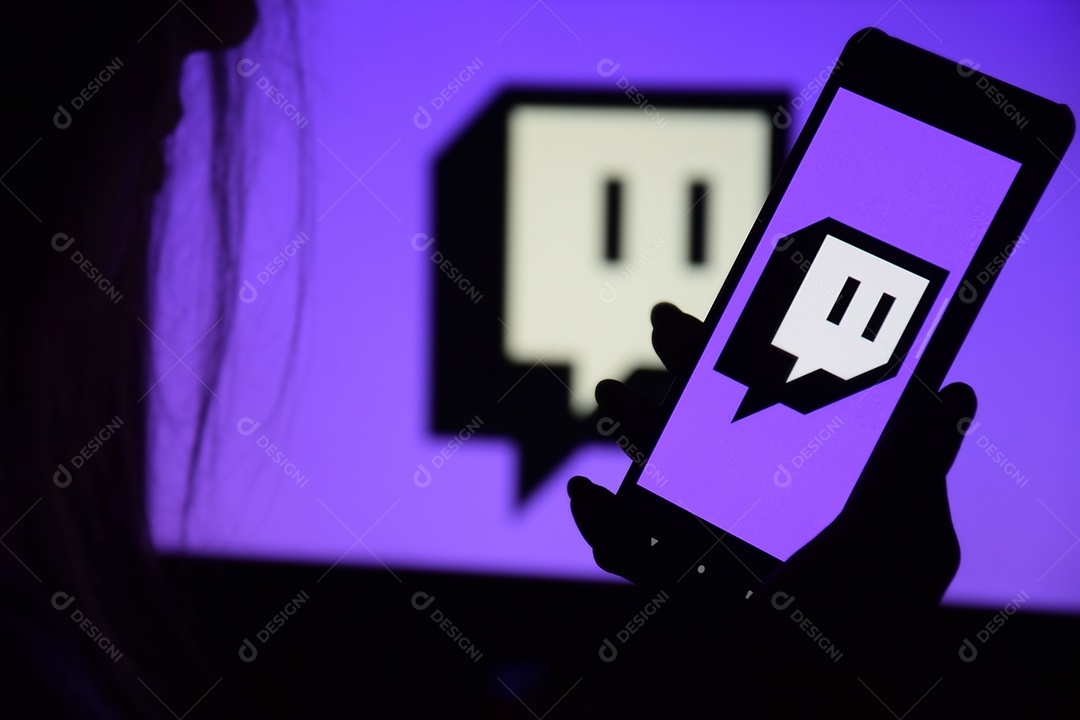 Tela Twitch nas mãos de uma jovem contra o fundo de um monitor
