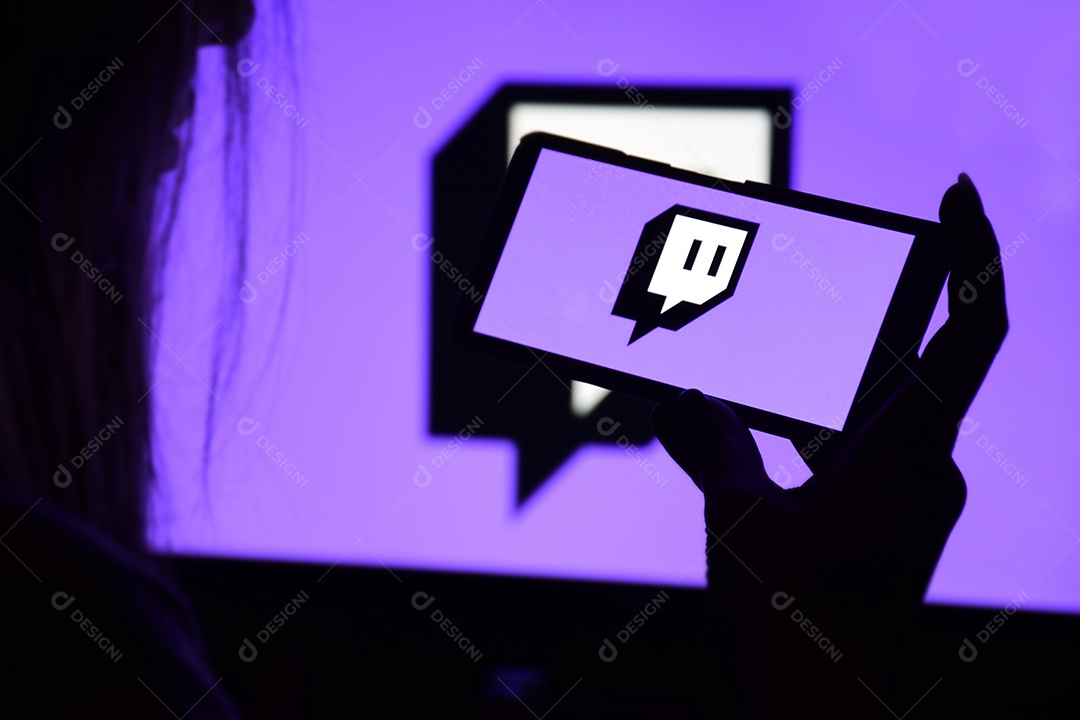 Tela Twitch nas mãos de uma jovem contra o fundo de um monitor