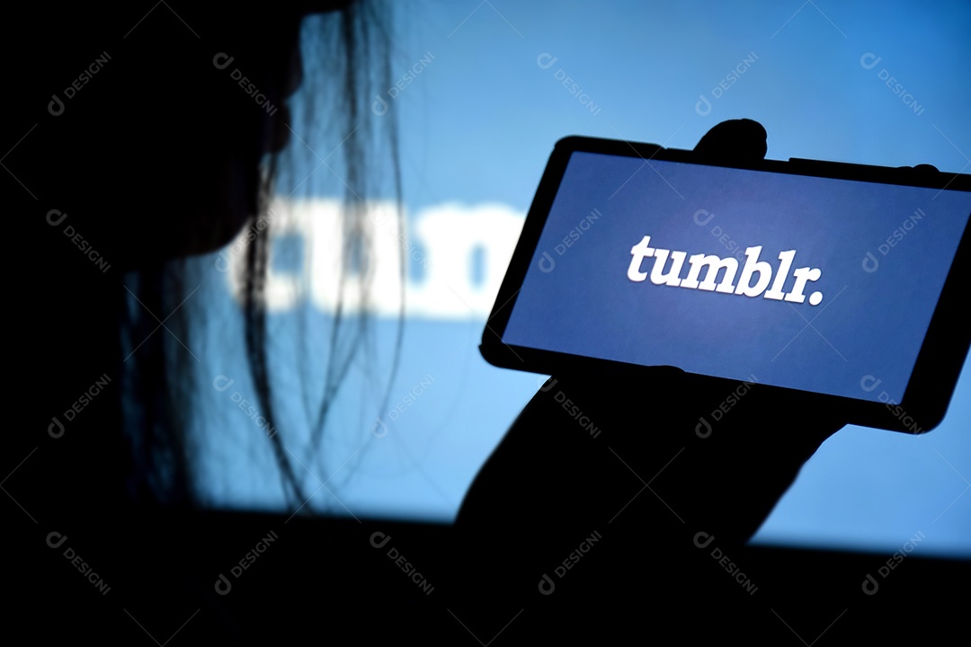 Um telefone com tela Tumblr nas mãos de uma jovem