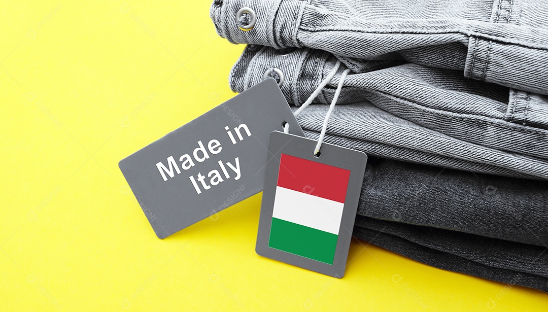 Peças de jeans com etiquetas de fabricação na Itália sobre fundo amarelo