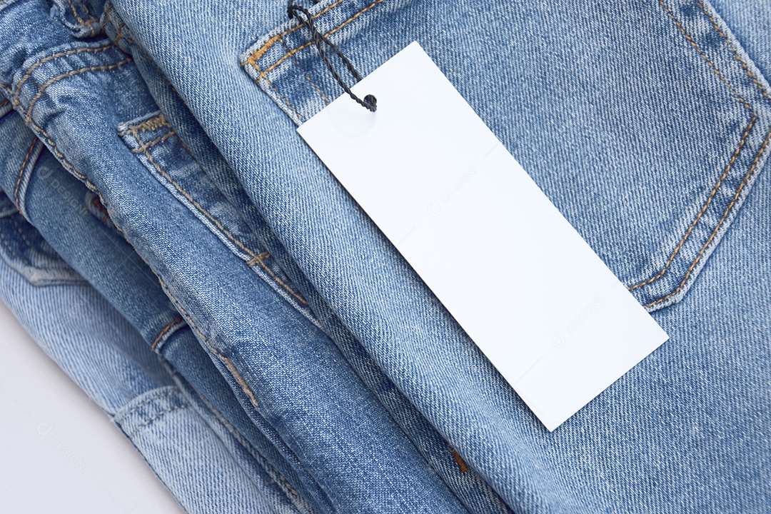 Quatro peças de jeans dobradas com etiqueta branca