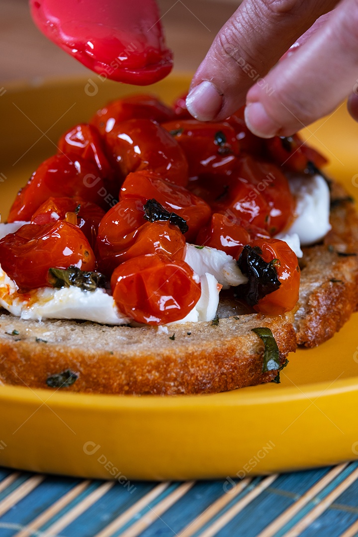 Preparando um lanche com uma fatia de pão de fermentação natural, recheado com tomate