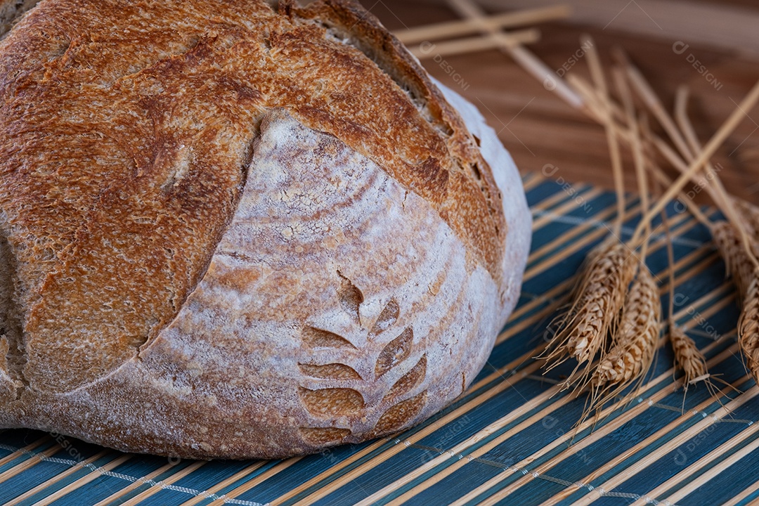 mãos femininas segurando pão artesanal de fermentação natural.