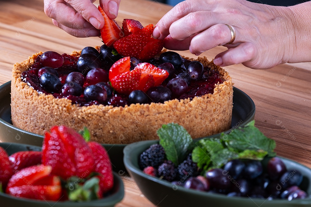 Torta doce com cobertura de creme e frutas vermelhas.