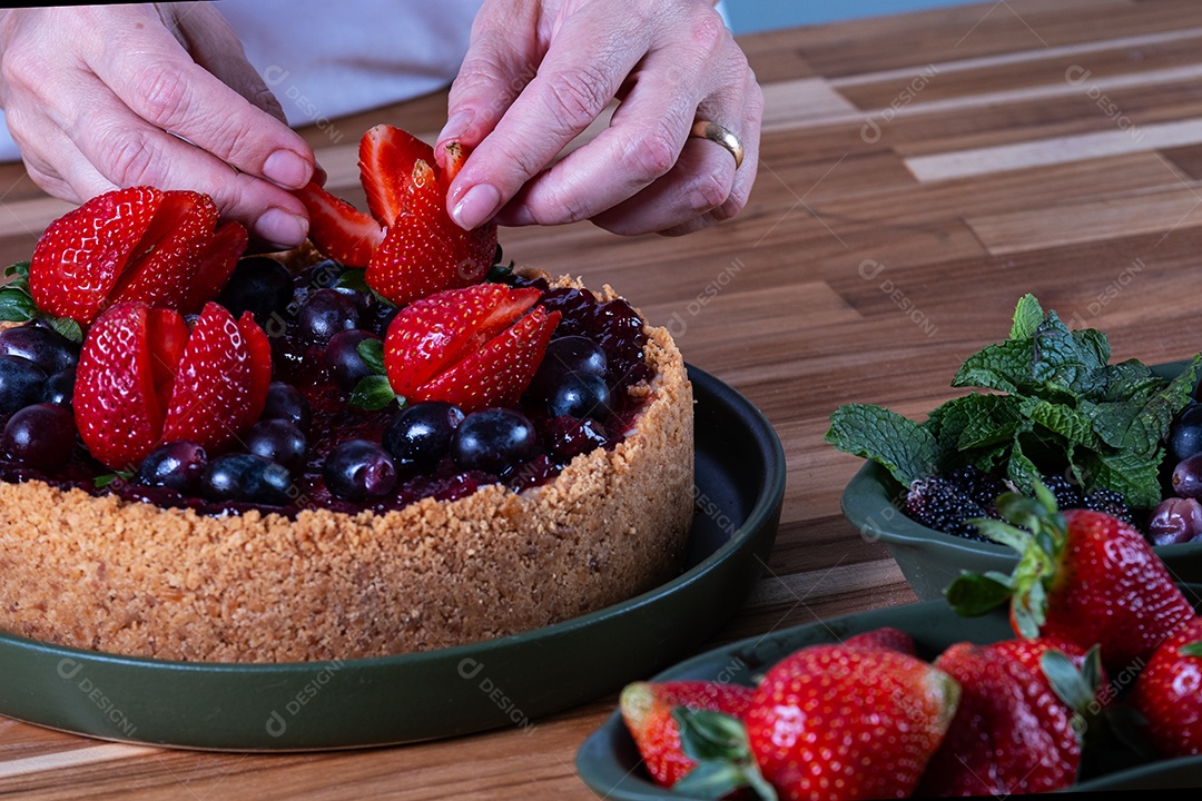 Torta doce com cobertura de creme e frutas vermelhas.