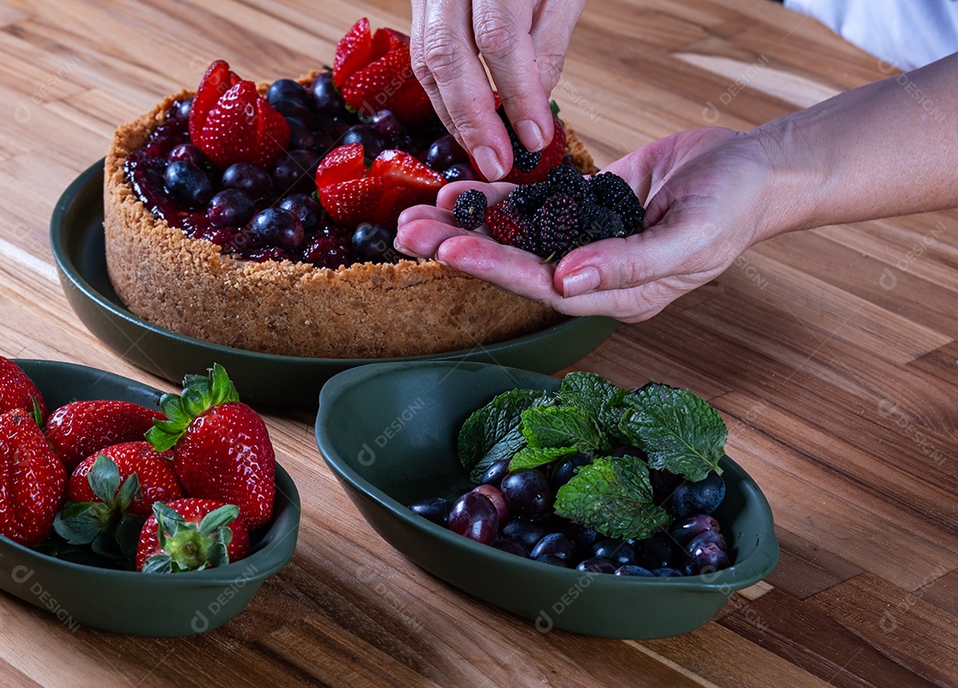 Torta doce com cobertura de creme e frutas vermelhas.