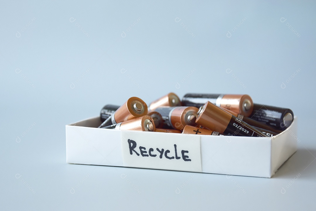 Recicle caixa com muitas pilhas sobre fundo azul