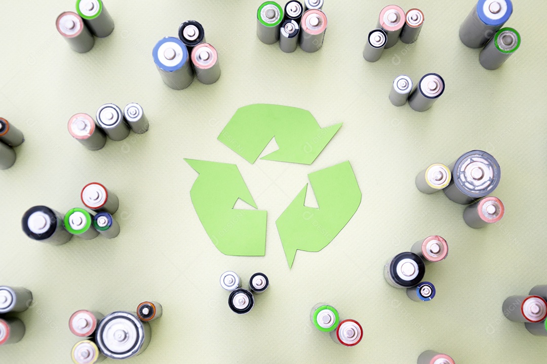 Símbolo de reciclagem ao meio rodeado de pilhas velhas