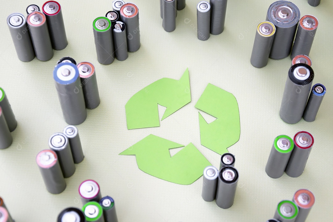 Muitas pilhas ao redor de símbolo de reciclar