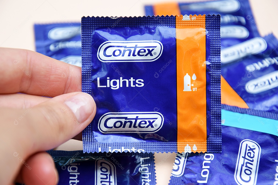 Mão segurando camisinha contex
