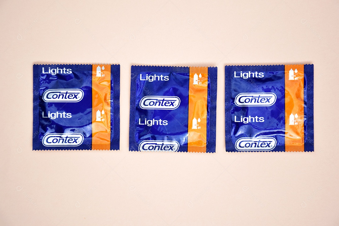 Três preservativo em um fundo rosa