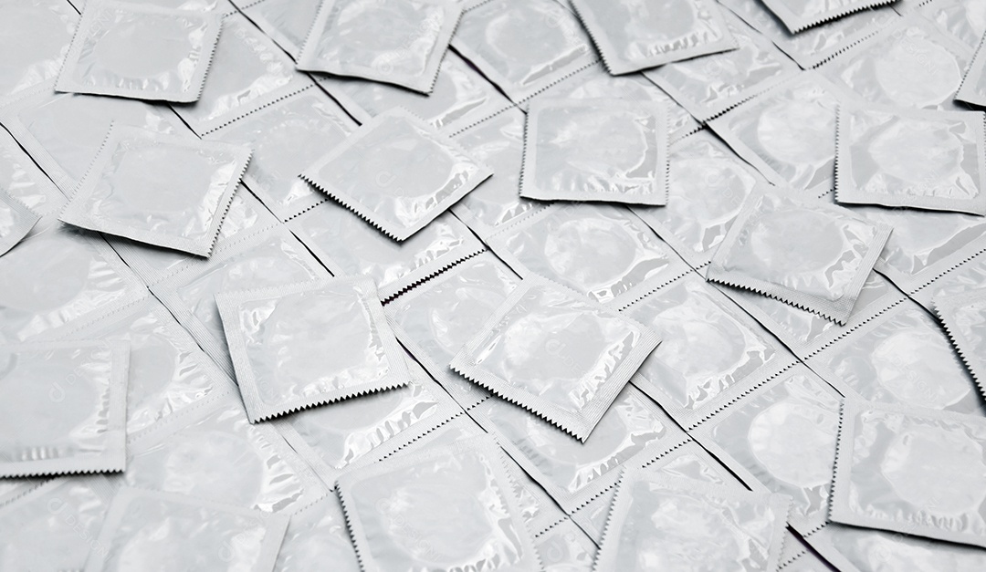 Muitos pacotes brancos de preservativos fechados como pano de fundo