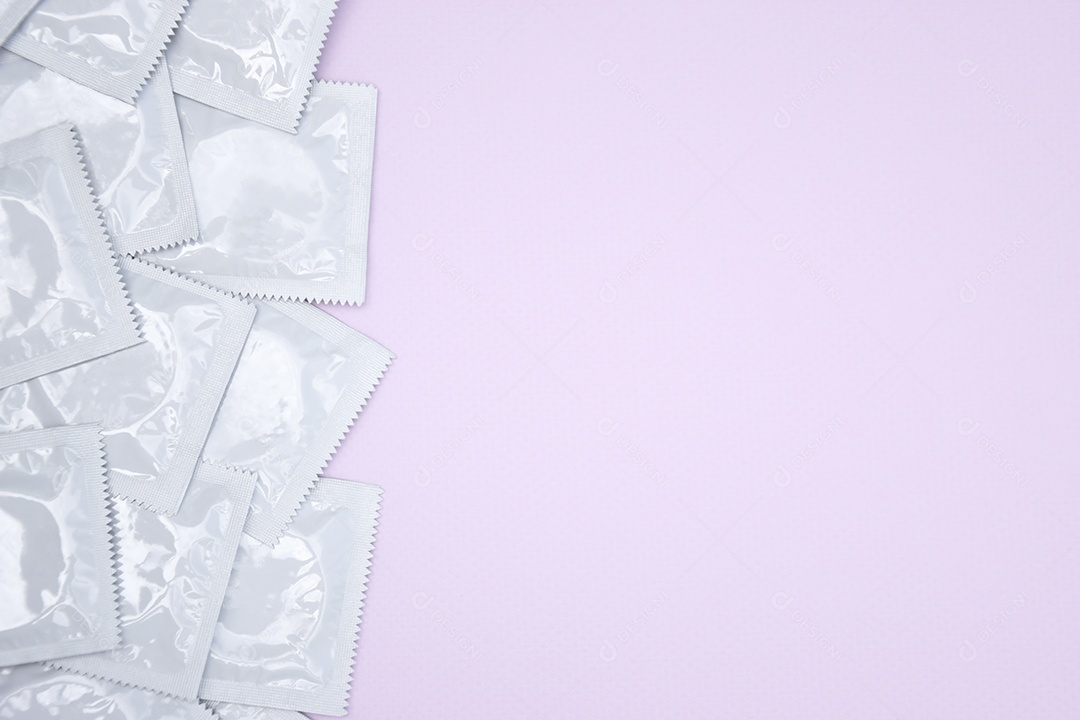 Várias camisinhas sobre fundo rosa