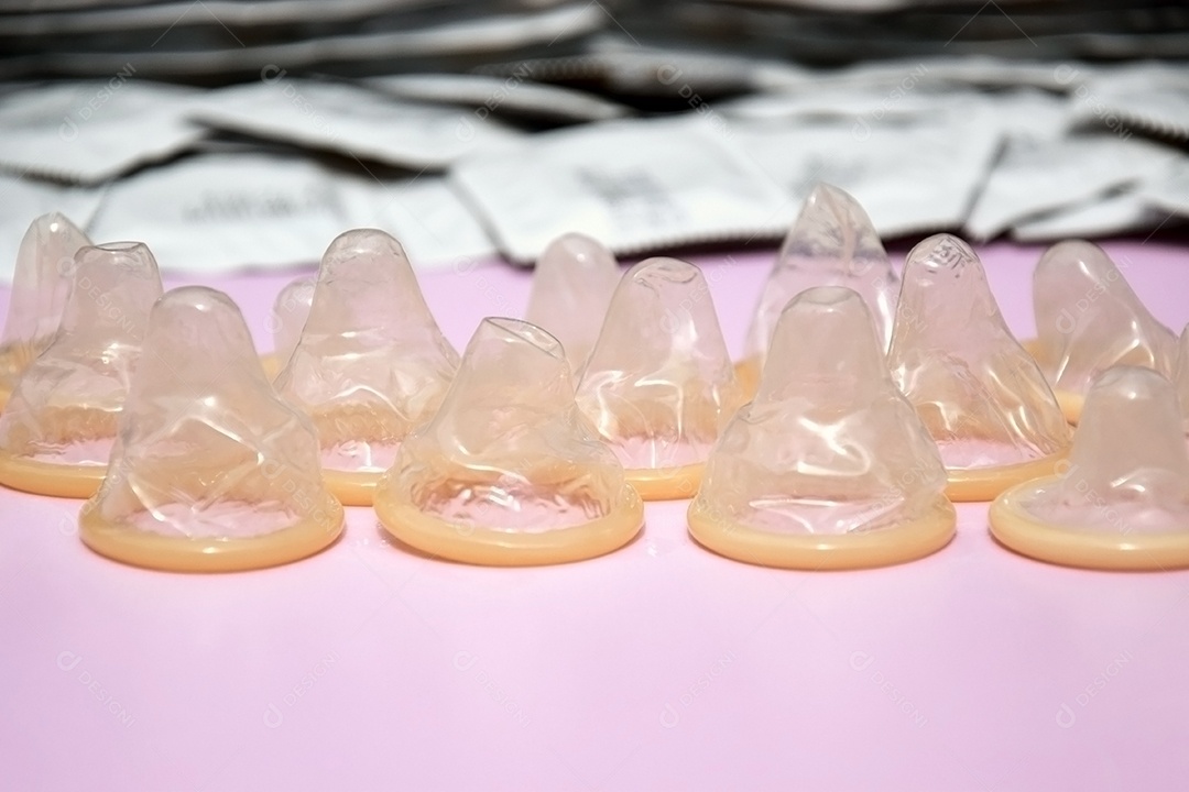 Preservativo de embalagem branca sobre fundo lilás