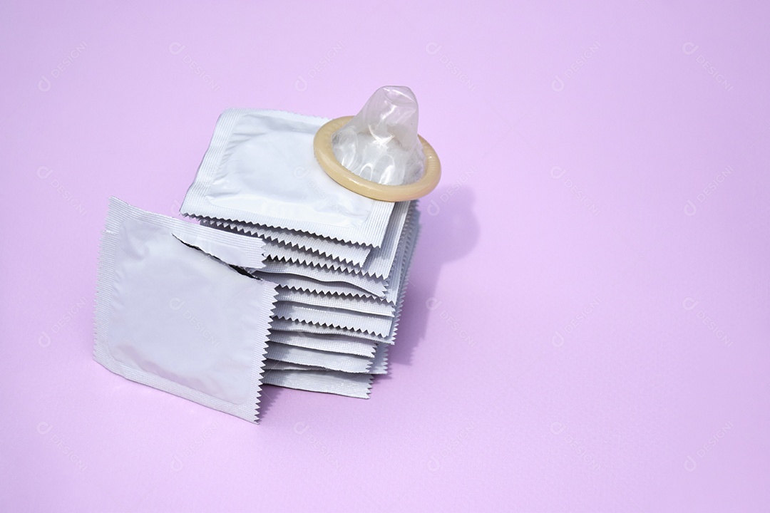 Pacotes de camisinha sobre fundo lilás