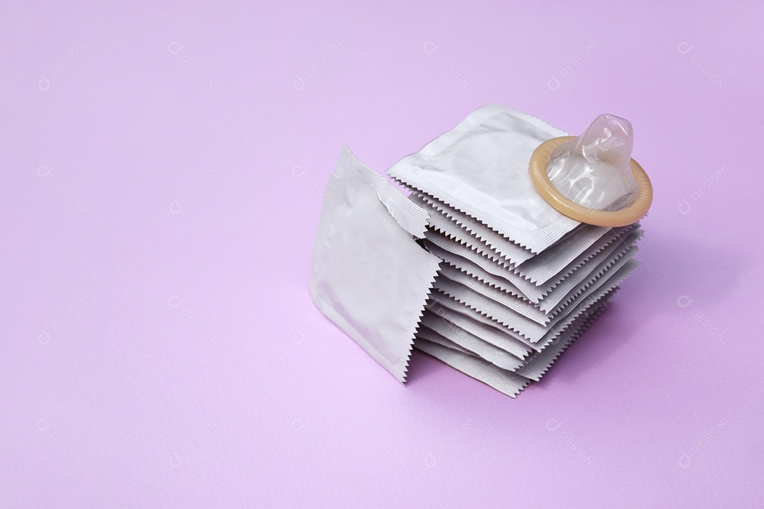 Preservativo de embalagem branca sobre fundo lilás