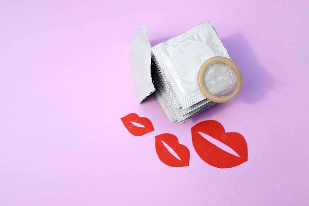 Pacote de camisinhas com uma aberta e beijos vermelhos sobre fundo rosa