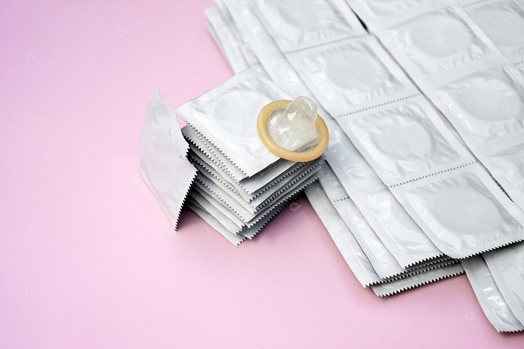 Muitos pacotes de camisinhas de embalagem branca sobre fundo lilás