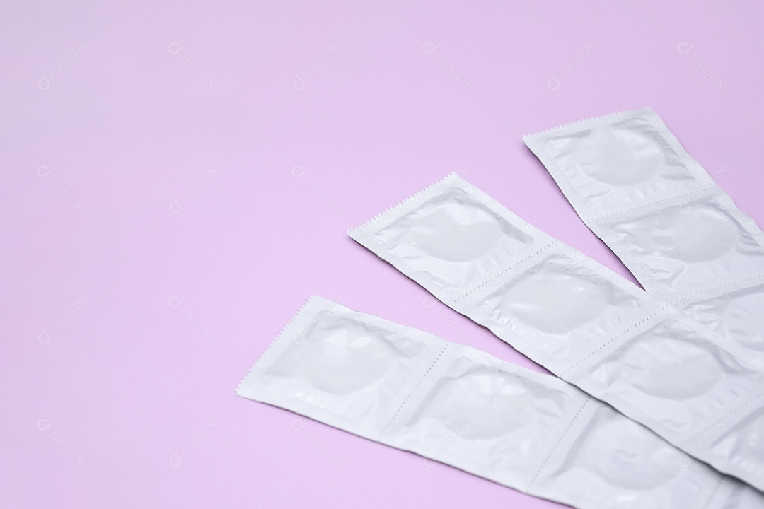 Preservativo de embalagem branca sobre fundo lilás
