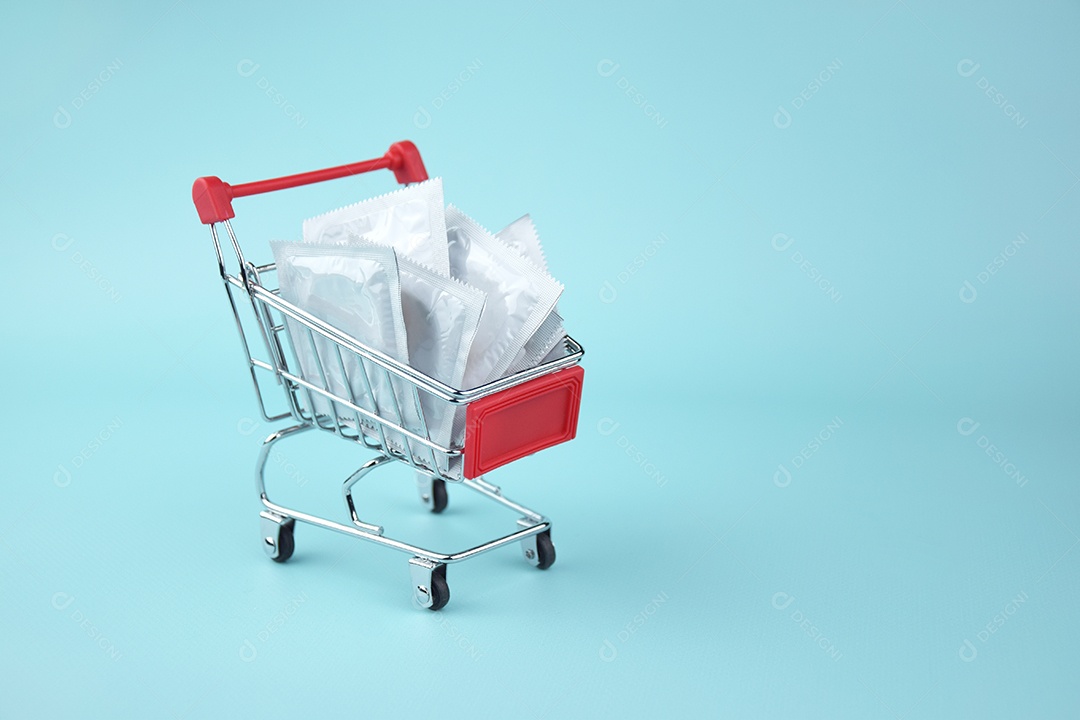 Carrinho de compra com várias camisinhas sobre fundo azul