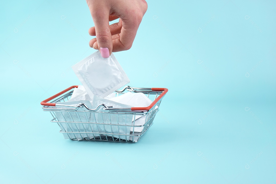 Cesta de compra com muitas camisinhas sobre fundo azul