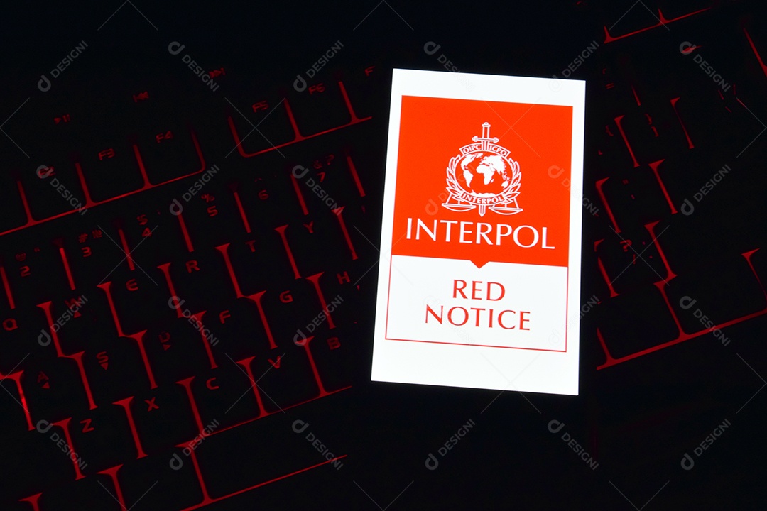 Pessoa segurando smartphone com logotipo da Interpol exibido na tela