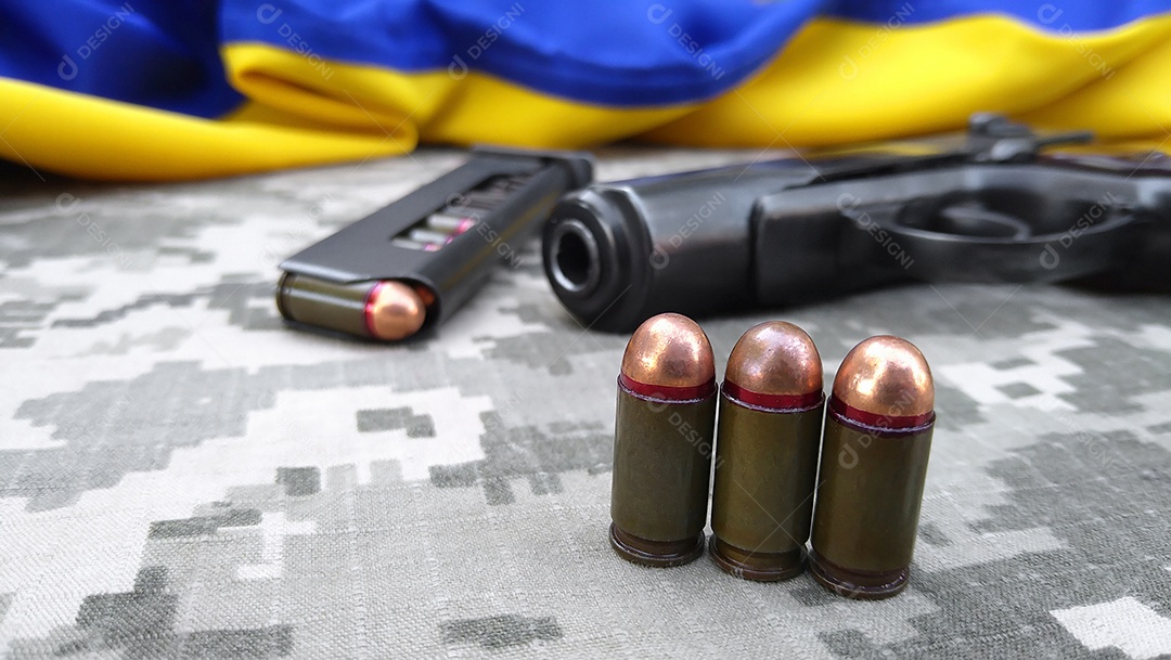 Balas e pentes com pistolas sobre fundo camuflado
