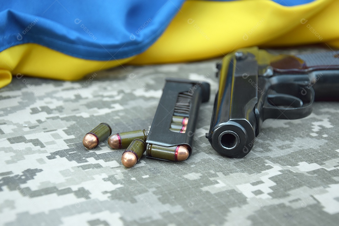 Pentes de munição e pistola sobre fundo de camuflagem