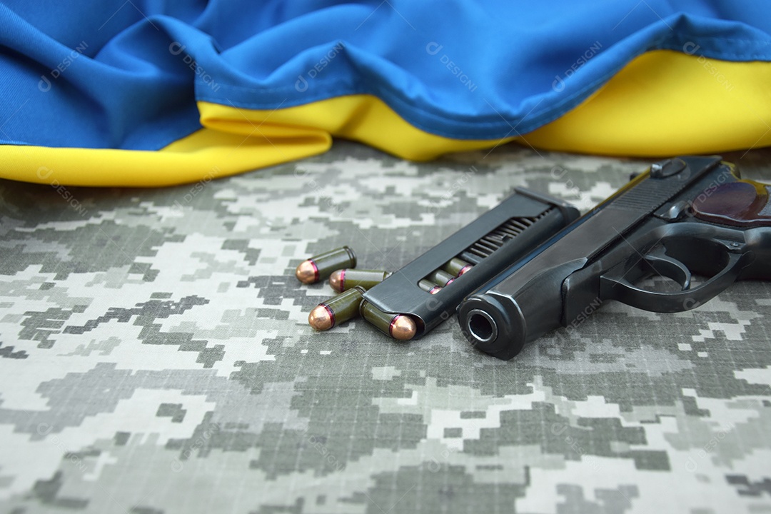 Pistola pentes com balas sobre fundo camuflado e bandeira ucraniana
