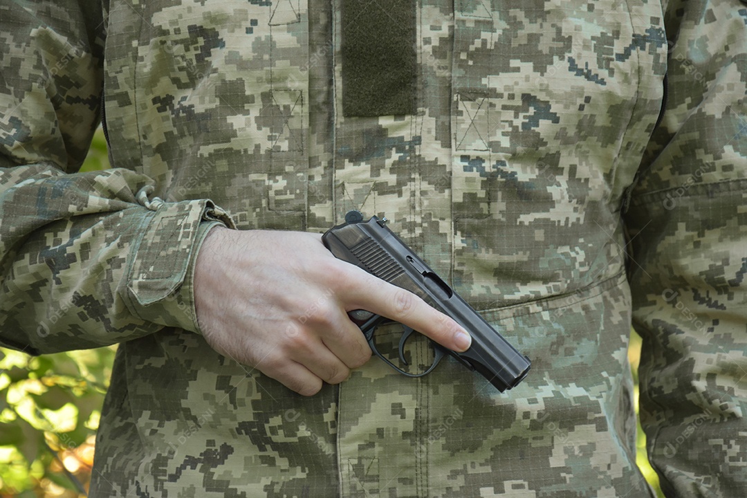 Mão de soldado segurando pistola