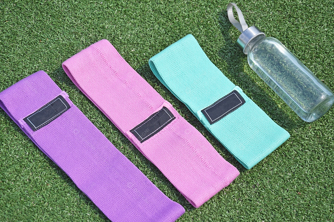 Elásticos de tecido multicolorido para fitness e garrafa na grama