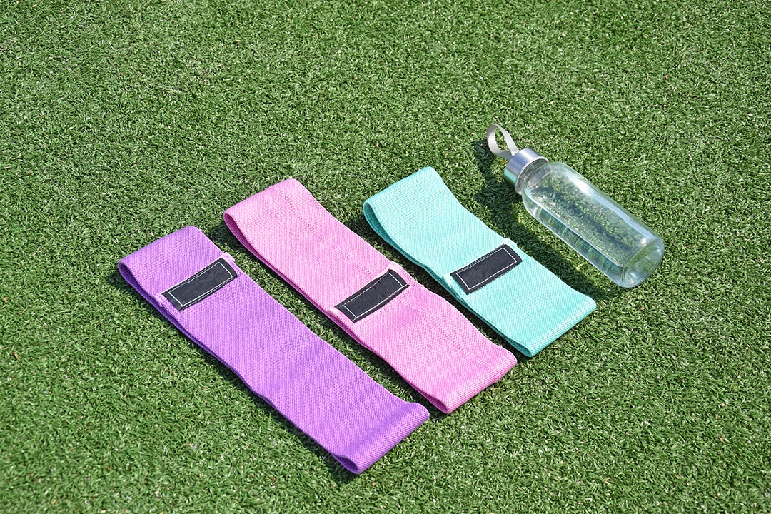 Elásticos de tecido multicolorido para fitness e garrafa na grama