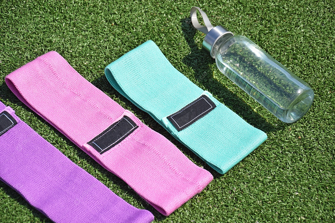 Elástico e garrafa fitness sobre grama