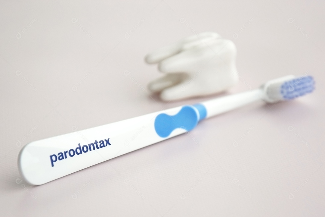 Escova de dente da Paradontax com uma figura de dente sobre fundo claro