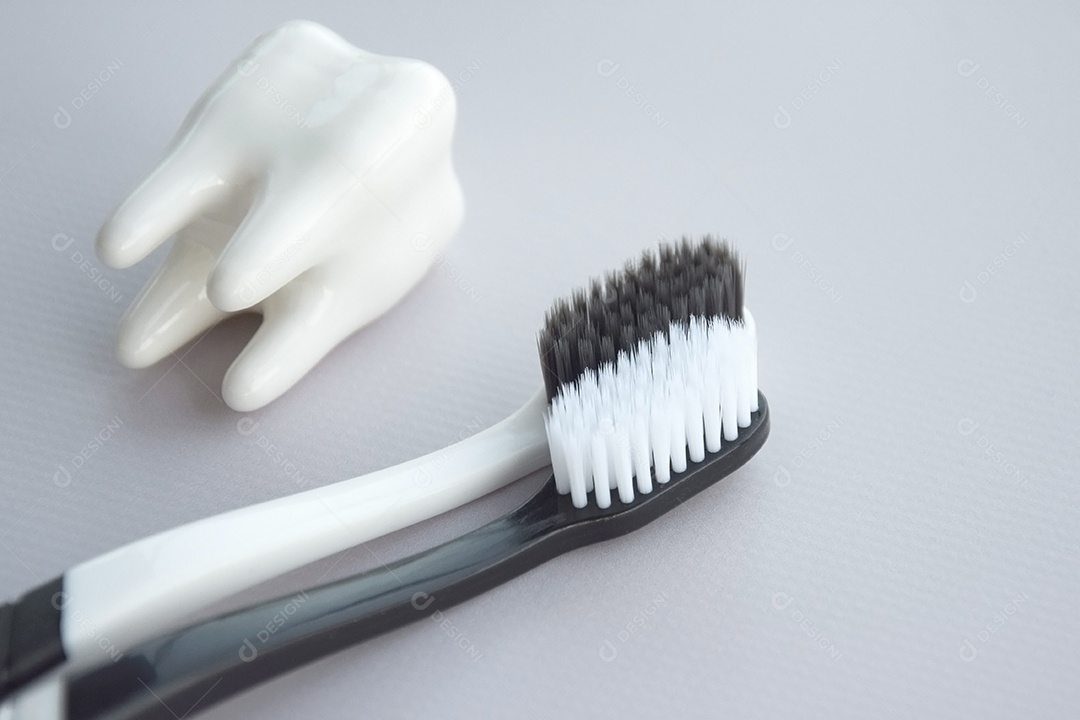 Duas escovas de dente com figura de dente ao lado conceito de saúde bucal
