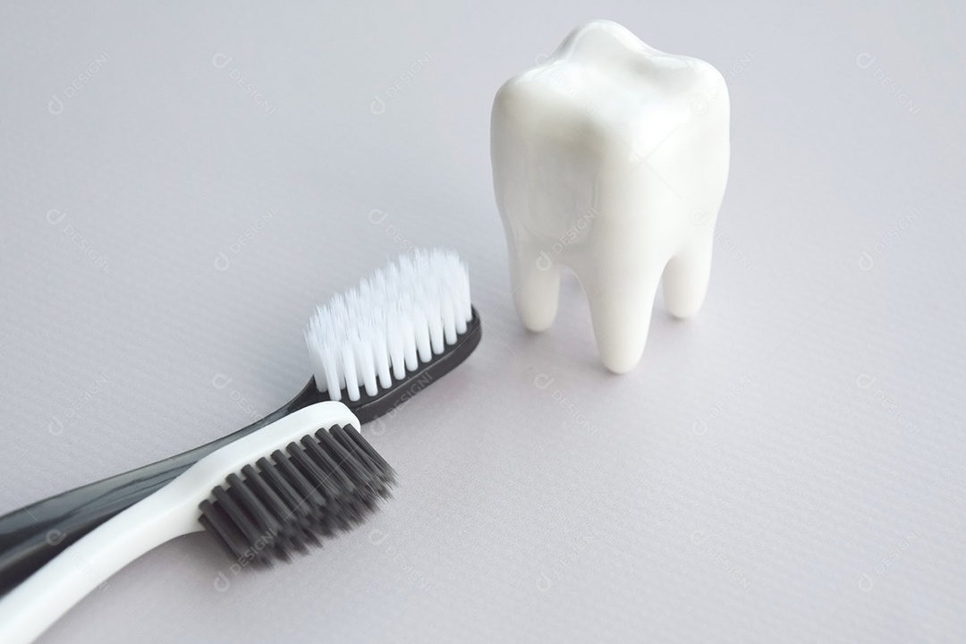 Duas escovas de dente com figura de dente ao lado conceito de saúde bucal
