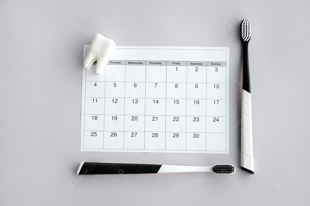 Calendário figura de dente e duas escovas de dentes preta sobre fundo claro