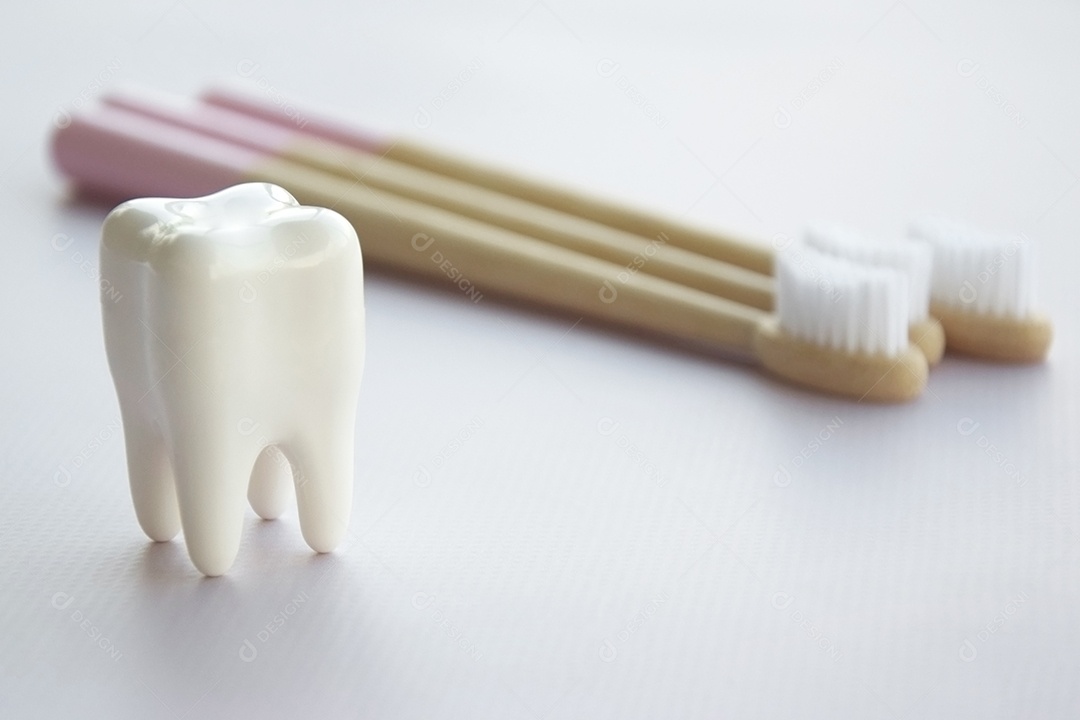 Duas escovas de bambu e figura de dente sobre fundo claro conceito de saúde bucal