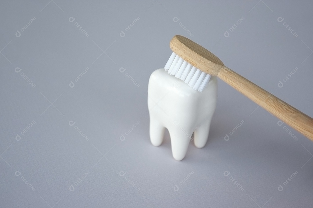 Figura de dente com escova de bambu em cima conceito de saúde bucal