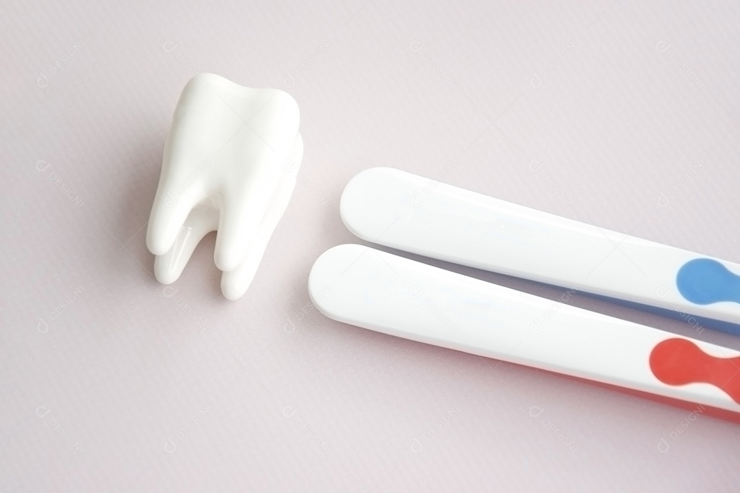 Duas escovas de dente com figura de dente ao lado conceito de saúde bucal