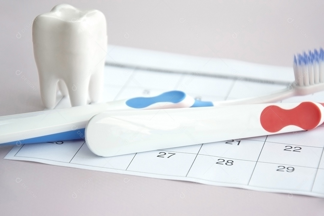 Escovas de dentes com uma pequena figura de dente sobre um fundo claro