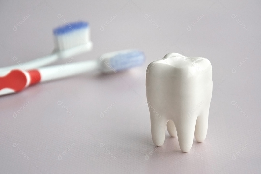 Escovas de dentes com uma pequena figura de dente sobre um fundo claro