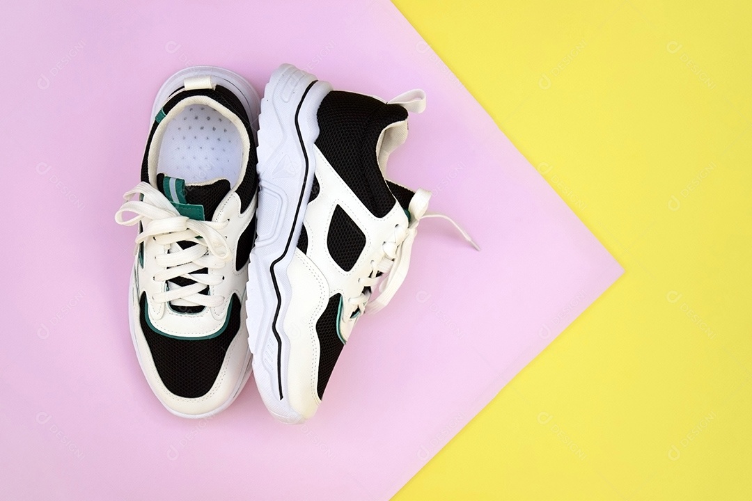 Tênis femininos brilhantes em fundo amarelo rosa claro