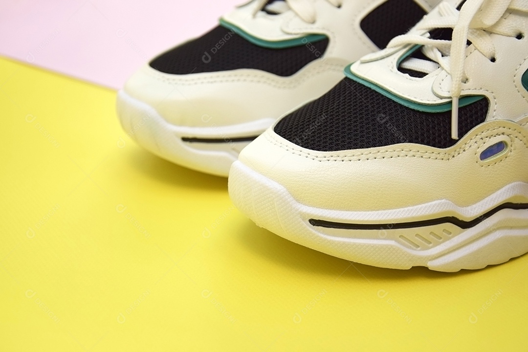 Tênis feminino lindo sobre fundo rosa e amarelo