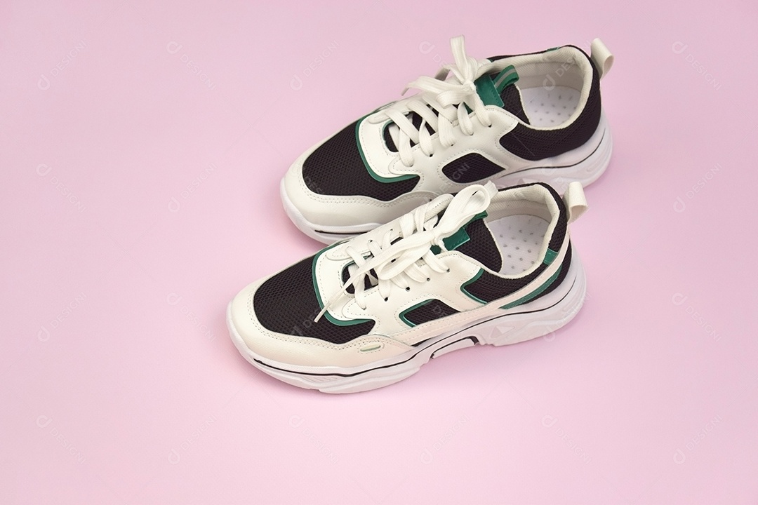 Par de tênis femininos brilhantes em fundo rosa claro