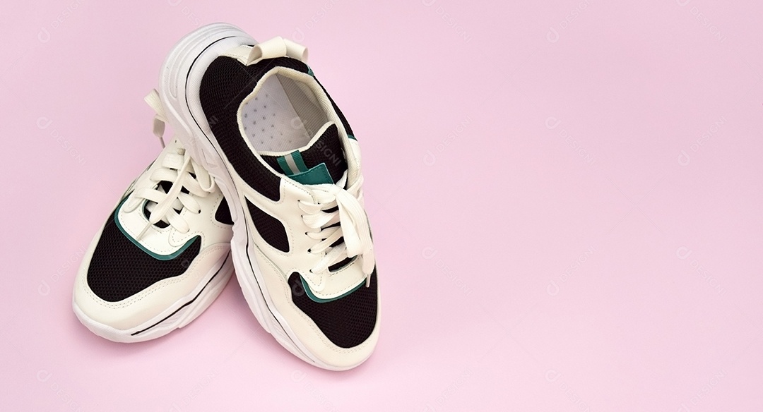 Tênis femininos brilhantes em fundo rosa claro conceito de blog ou revista de moda