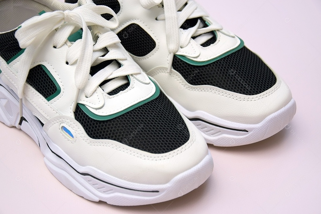 Par de tênis femininos brilhantes em fundo rosa claro